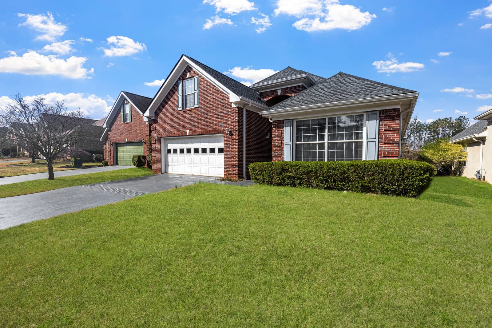 Brick home with a freshly mowed lawn and trimmed hedges
